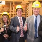Five people standing side by side wearing hard hats and holding their thumbs up