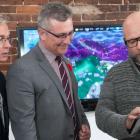 Minister MacDonald and  MP Sean Casey look at tablet heald by icejam founder Stu Duncan