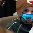 image of a child with a mask on receiving his vaccination