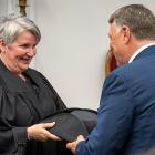 image of a person handing another person an official speaker's hat