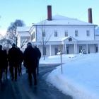 A group of people walk toward Government House.