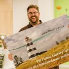 image of a person holding a large postcard with a picture of a lighthouse on it