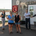 Staff from the Lobster Barn stand, along with others, outside their restaurant holding their winning plaque