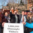 Photo shows Minister MacDonald holding a sign with several other individuals that says "one million overnight stays"