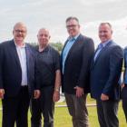 Six men stand on the bank of the Morell river following a federal provincial funding announcement