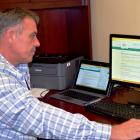 Minister of Communities, Land and Environment Robert Mitchell reviews the new department webpage that invites Islanders to submit feedback on the upcoming Municipal Government Act.