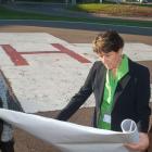 Minister Biggar and Minister henderson and one other person review construction plans near the PCH Helipad