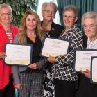 Seven women stand in a row, five of them holding certificates for Senior Islander of the Year