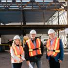 image of three people standing in front of a building construction site