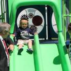 Dakota takes a slide on the new therapeutic playground while pediatric nurse manager Julie Smith and Health Minister Robert Henderson look on.