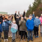 image of a small group of elementary students wearing lunar eclipse glasses looking skyward and pointing.