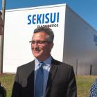 Minister Heath MacDonald and two men standing in from of Sekisui Diagnostics building
