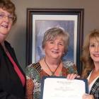 Three women holding certificate for senior of the year award
