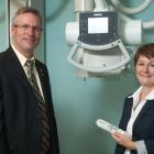 Minister of Health and Wellness, Robert Henderson and three people stand n front of a diagnostic imaging machine.