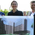 three people holding a picture of a building