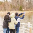 image of 4 people standing near the edge of a pond