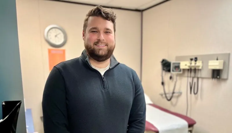 Un homme sourit dans une chambre d&#039;hôpital.