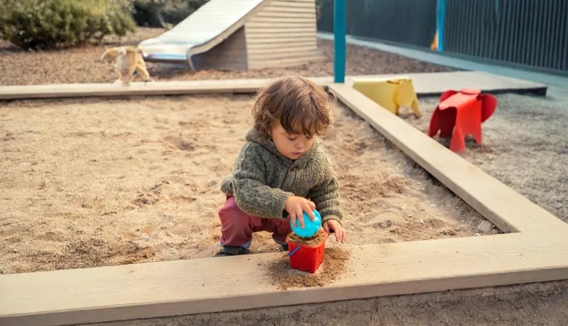 Image of a child's hand playing in a sand table