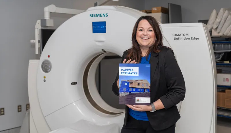 Finance Minister Jill Burridge holding the cover of the 2025 Capital Budget