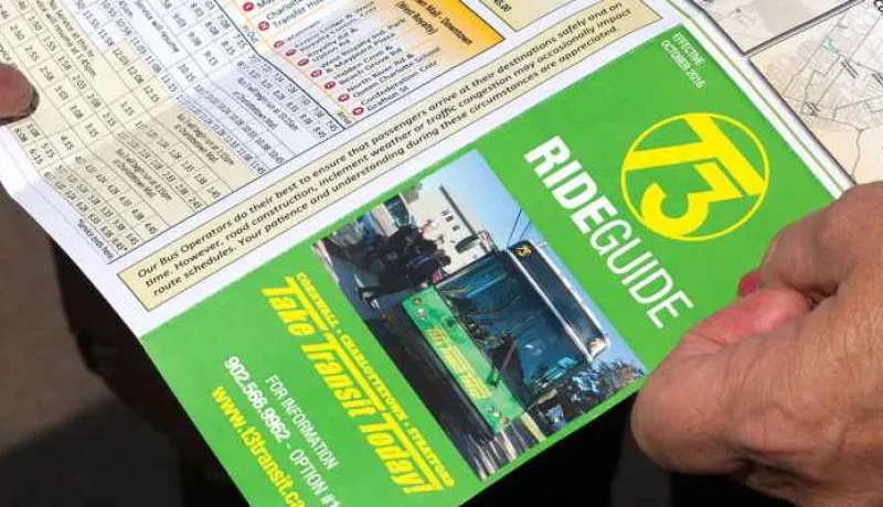 People holding a copy of transit schedule