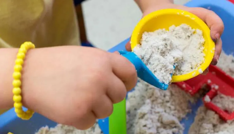 Image of a child&#039;s hand playing in a sand table