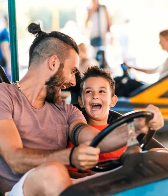 Man and a little boy in a bumper car at an amusement park