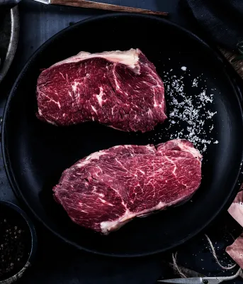 Cuts of steak in a cast iron pan.