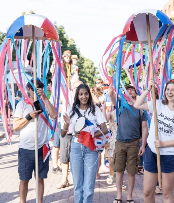 Some youth celebrate National Acadian Day in the street with bright red, white and blue colors.