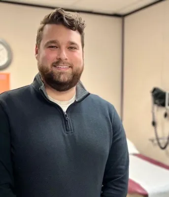A man smiles in a hospital room.