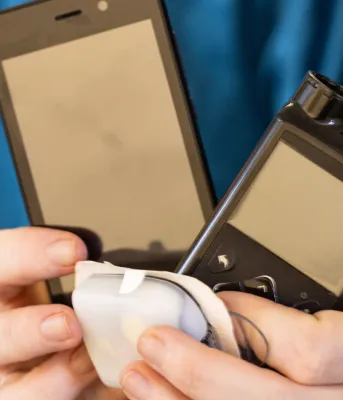 A person holds an insulin pump in their hands.