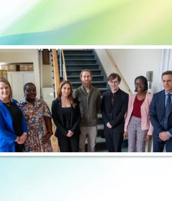image of people standing shoulder to shoulder in a building at the bottom of stairs