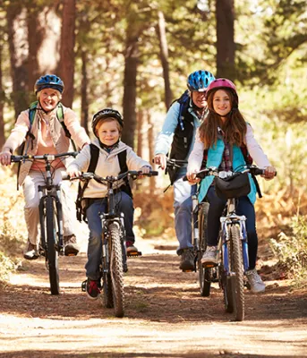 Grandparents and kids cycling on a forest trail