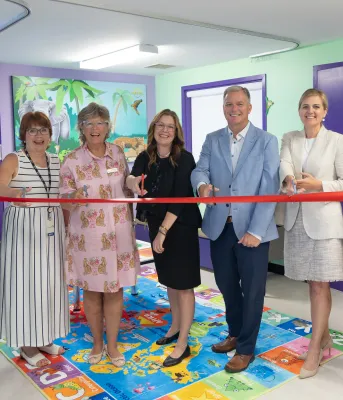 Seven people gathered in a colorful Smilezone area to cut the ceremonical ribbon.