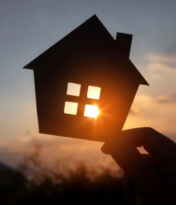 cardboard house cutout with the sun in the background