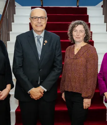 Four people stand next to each other.