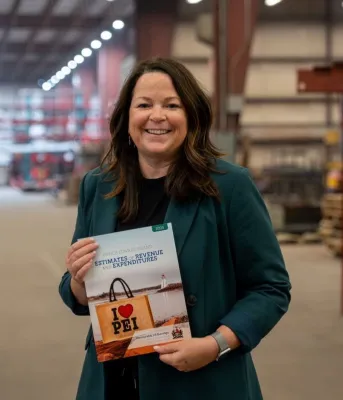 Minister Jill Burridge holding a copy of the 2026-2026 Operating Budget