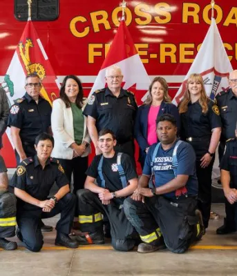 Ministers and firefighters pose in front of a firetruck.