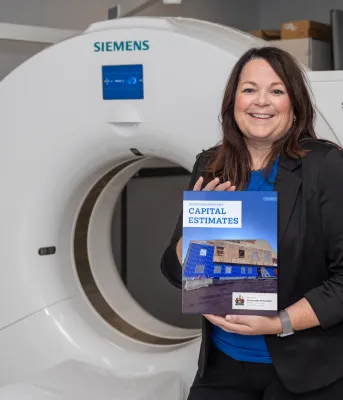 Finance Minister Jill Burridge holding the cover of the 2025 Capital Budget