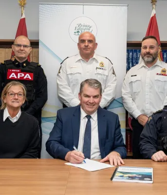 Le ministre et cinq officiers se tiennent devant une étagère à livres.