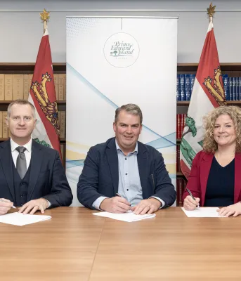 Three people sit next to each other at a table.