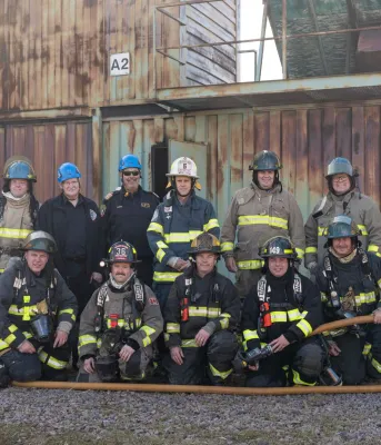 A bunch of men dressed in firefighting gear.