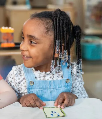 Un gros plan d'une jeune fille noire avec des perles dans les cheveux.