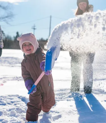 Un jeune enfant joue dans la neige.