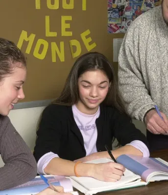 Un enseignant aidant deux élèves