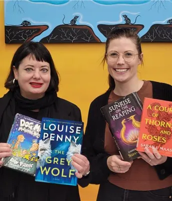 Deux bibliothécaires tiennent plusieurs livres de la liste des meilleurs ouvrages.