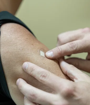 putting band-aid on arm after a vaccination