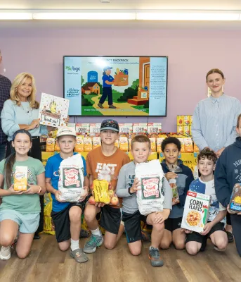 Un groupe d'adultes et d'enfants tenant des sacs de pommes de terre de l'Île-du-Prince-Édouard.