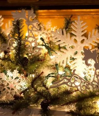 mantle decorated with spruce branches and lights