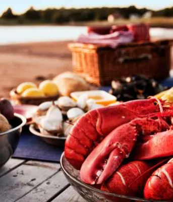 Rustic table set with PEI oysters, cooked lobster, mussels, lemon and lime