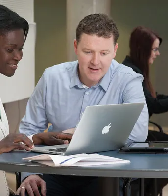 two people looking at a computer at a workstation